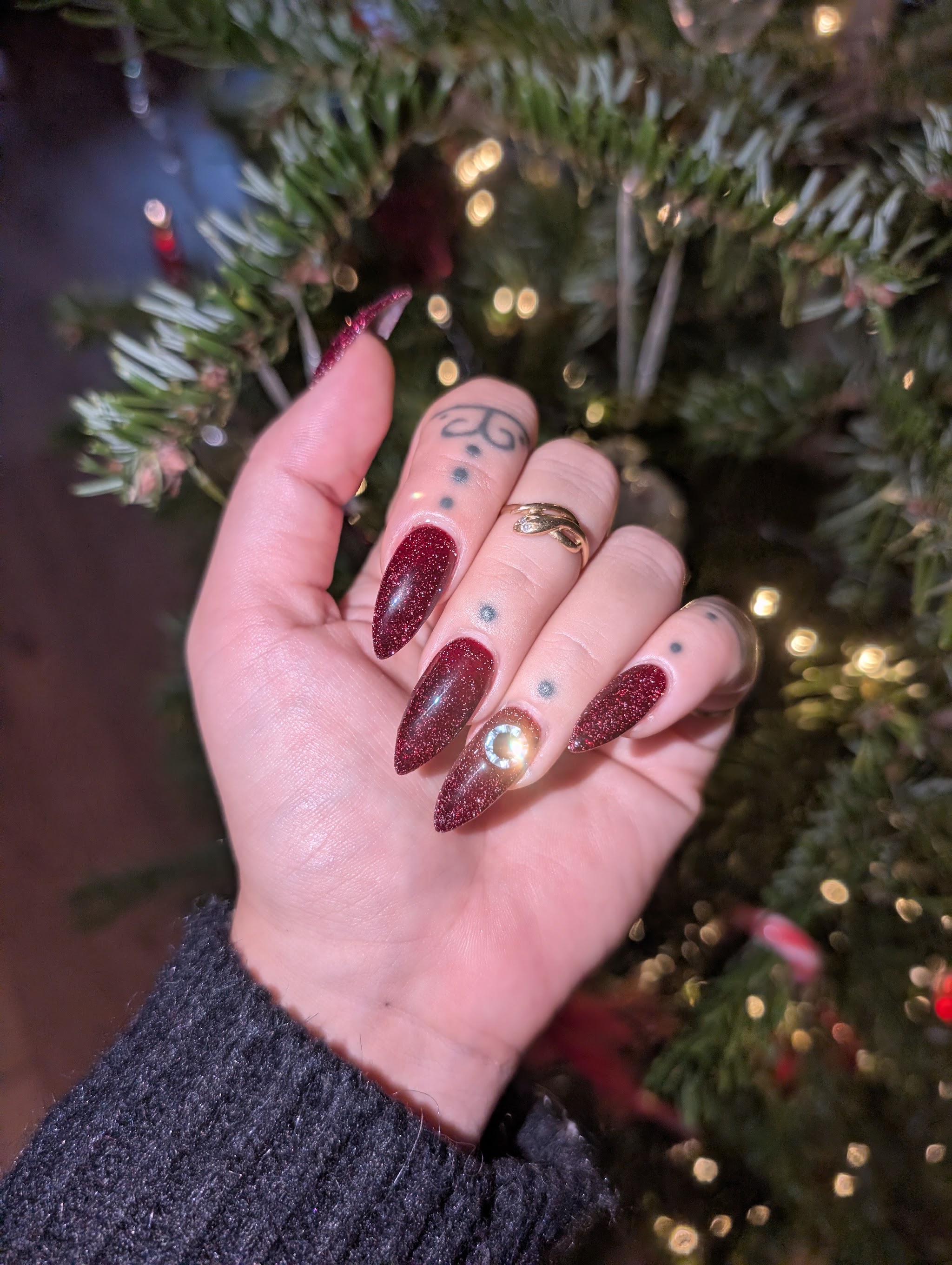 Rode glitternagels in amandelvorm voor een kerstboom, foto van Erinn Mira